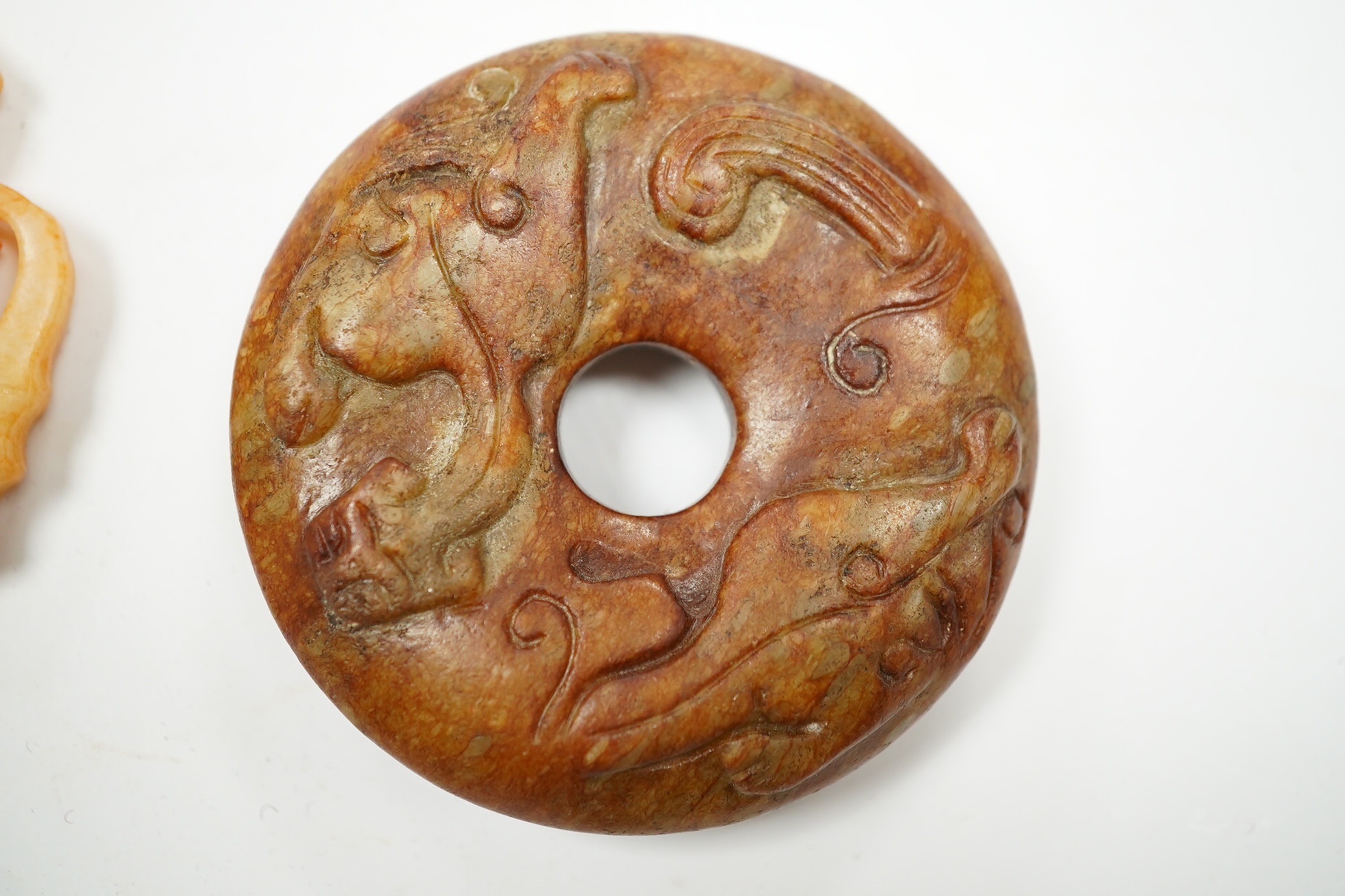 A Chinese russet and green jade bi disc and another plaque, largest 7cm diameter. Condition - good